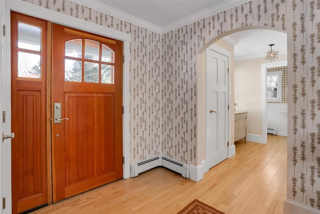 foyer featuring a baseboard heating unit, ornamental molding, and light wood-type flooring