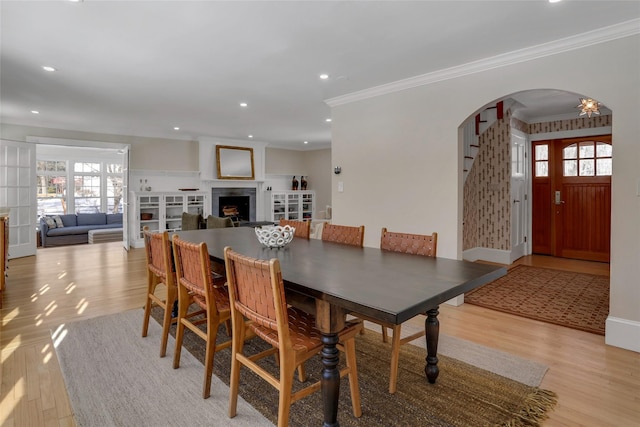 dining area with crown molding and light wood-type flooring