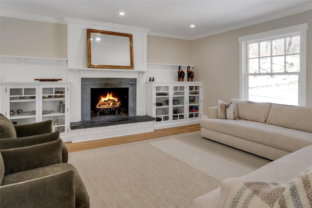 living room with crown molding, hardwood / wood-style flooring, and a high end fireplace