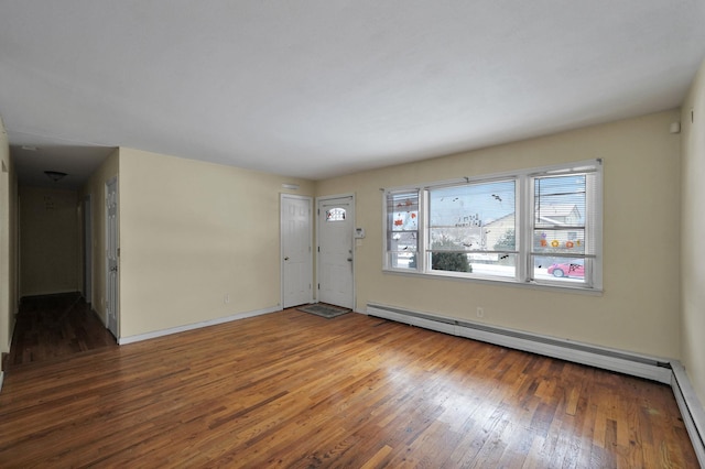 spare room featuring wood-type flooring and a baseboard radiator