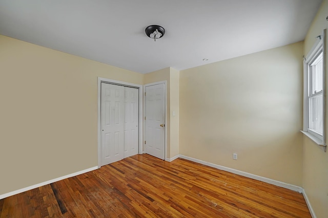 unfurnished bedroom with a closet and wood-type flooring