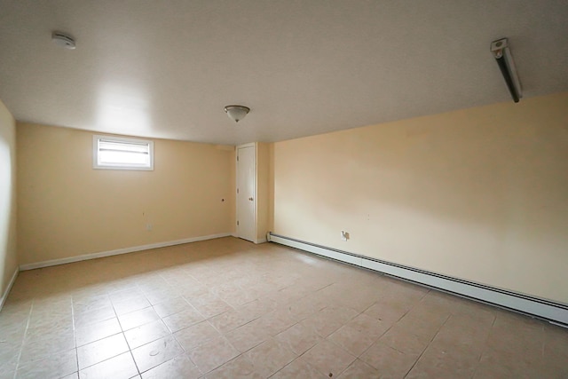 tiled spare room with a baseboard heating unit