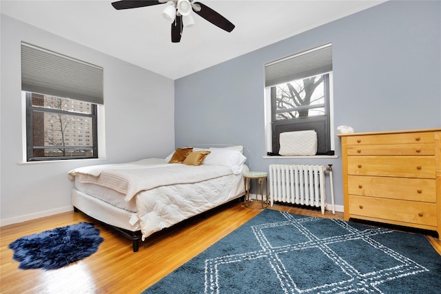 bedroom featuring ceiling fan, dark hardwood / wood-style floors, and radiator heating unit