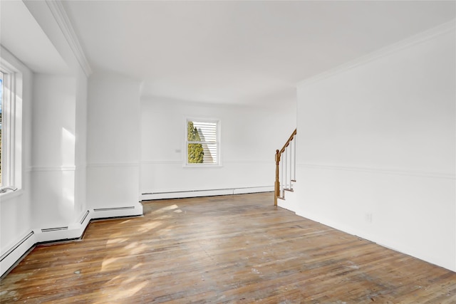 spare room with hardwood / wood-style flooring, ornamental molding, and a baseboard heating unit