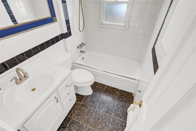 full bathroom with tiled shower / bath, vanity, toilet, and tile walls