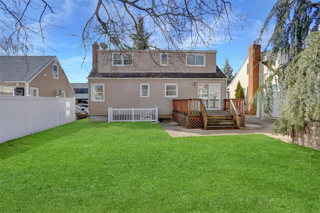 back of house featuring a wooden deck and a yard