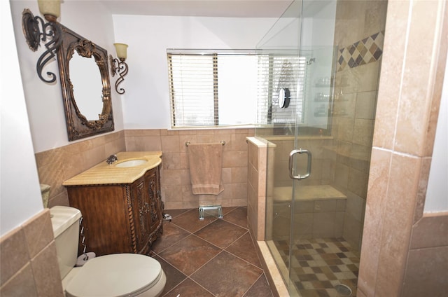 bathroom with an enclosed shower, tile patterned floors, tile walls, toilet, and vanity