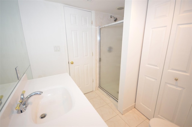 bathroom featuring sink, an enclosed shower, and tile patterned flooring