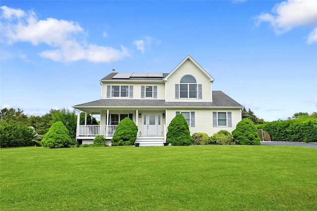 view of front of home featuring a front lawn, solar panels, and a porch