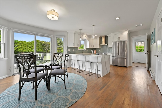 dining space with dark wood-type flooring and a baseboard heating unit