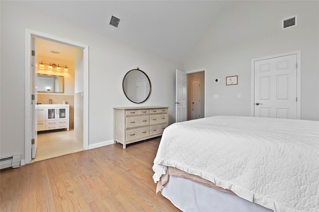 bedroom with wood-type flooring, high vaulted ceiling, a baseboard radiator, and ensuite bathroom