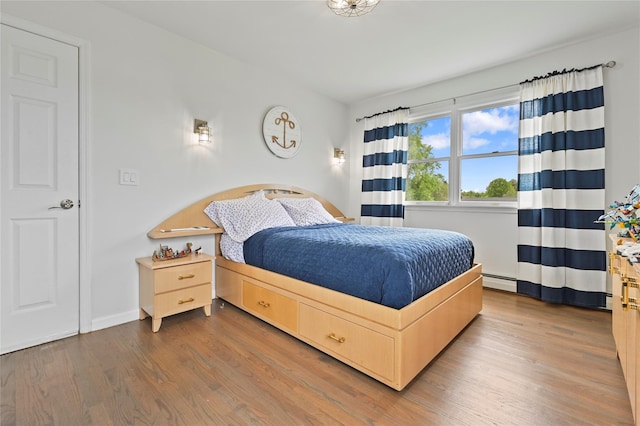 bedroom with dark wood-type flooring and a baseboard radiator