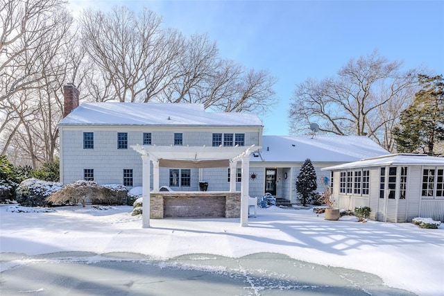 snow covered property featuring a pergola