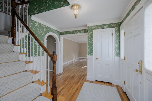 entrance foyer with crown molding and light hardwood / wood-style flooring