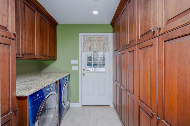 laundry room featuring cabinets, separate washer and dryer, and light tile patterned floors