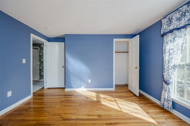 unfurnished bedroom with wood-type flooring and a closet