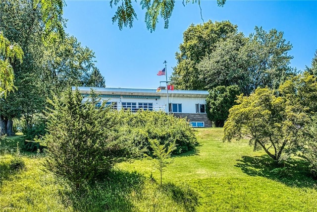 rear view of house featuring a lawn