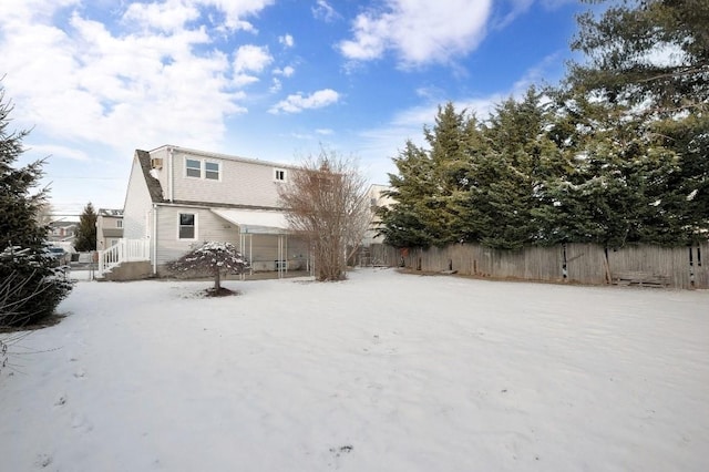 view of snow covered back of property