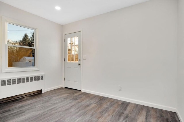 empty room with radiator and wood-type flooring