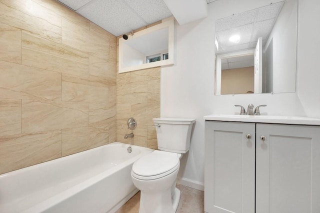 full bathroom with toilet, vanity, tiled shower / bath, tile patterned floors, and a paneled ceiling