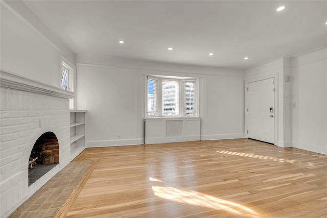 unfurnished living room featuring a brick fireplace and light hardwood / wood-style floors