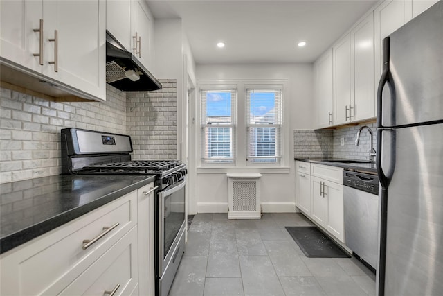 kitchen with tasteful backsplash, white cabinetry, sink, light tile patterned floors, and stainless steel appliances