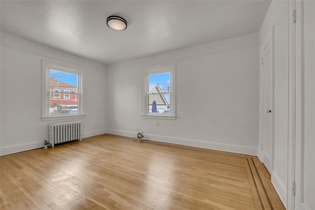 unfurnished bedroom with radiator heating unit and light wood-type flooring