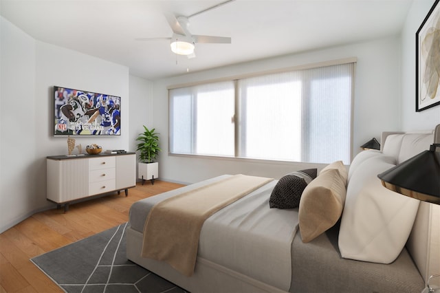 bedroom with multiple windows, ceiling fan, and light hardwood / wood-style flooring