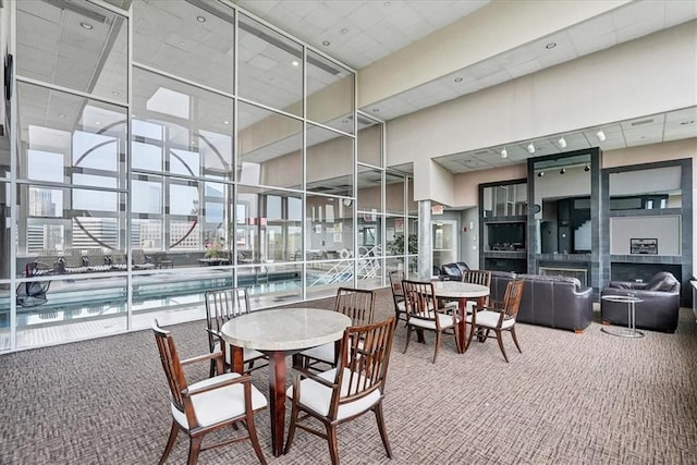 carpeted dining area featuring a high ceiling