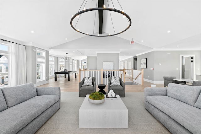 living room featuring a notable chandelier, vaulted ceiling, ornamental molding, and light hardwood / wood-style floors