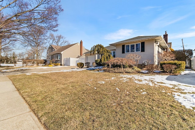 view of front of property featuring a garage and a front lawn