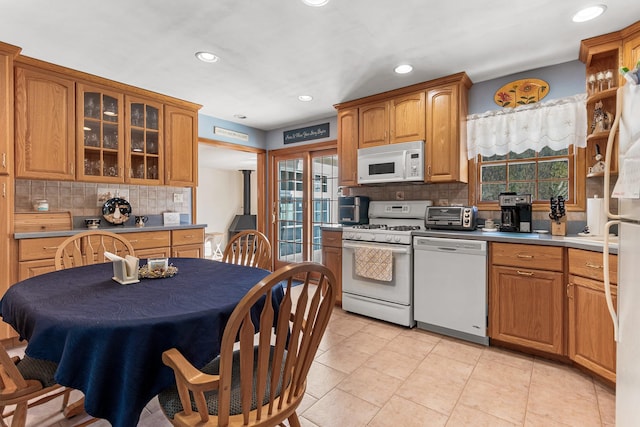 kitchen with light tile patterned flooring, white appliances, and backsplash