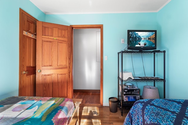 bedroom with crown molding and hardwood / wood-style floors