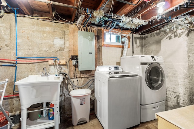 clothes washing area with independent washer and dryer, electric panel, and sink