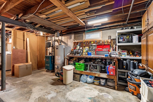 basement with washer / dryer, a workshop area, and water heater