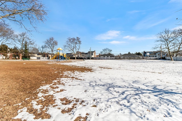 yard covered in snow with a playground