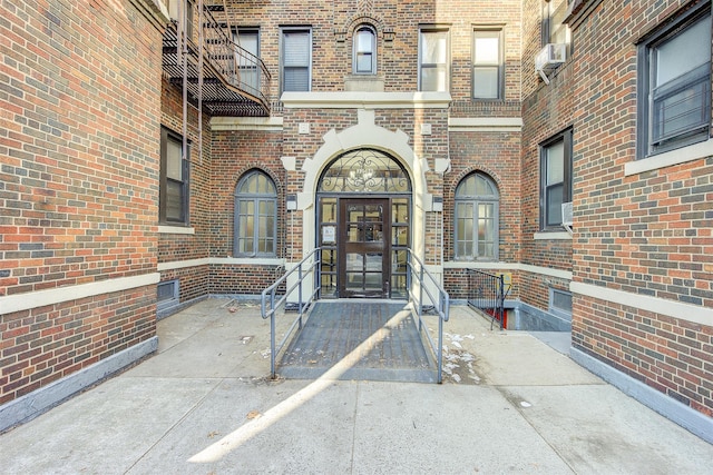 entrance to property featuring cooling unit and brick siding