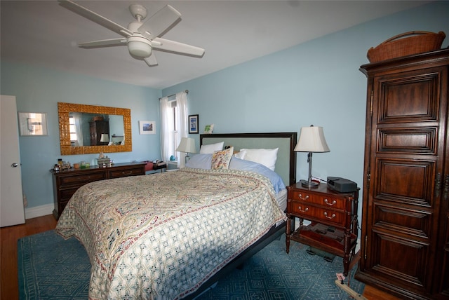 bedroom featuring baseboards, dark wood-type flooring, and ceiling fan