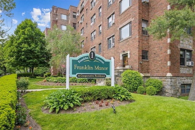 community / neighborhood sign featuring a lawn