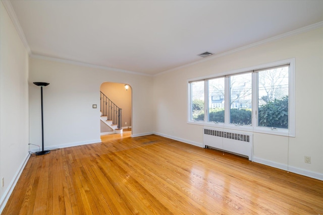 empty room featuring crown molding, light hardwood / wood-style flooring, and radiator