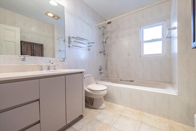 full bathroom featuring toilet, tile walls, tile patterned floors, vanity, and tiled shower / bath