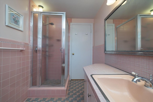 bathroom featuring tile walls, a shower with shower door, and vanity