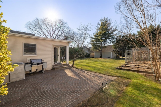 view of patio with a garage, an outbuilding, and area for grilling