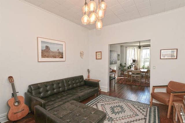 living room with a chandelier, crown molding, and dark hardwood / wood-style flooring