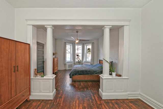 unfurnished bedroom with decorative columns and dark hardwood / wood-style flooring