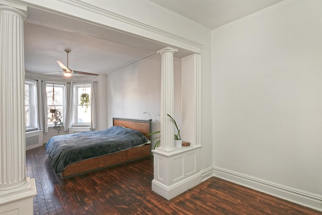 bedroom featuring decorative columns, ceiling fan, and dark hardwood / wood-style flooring