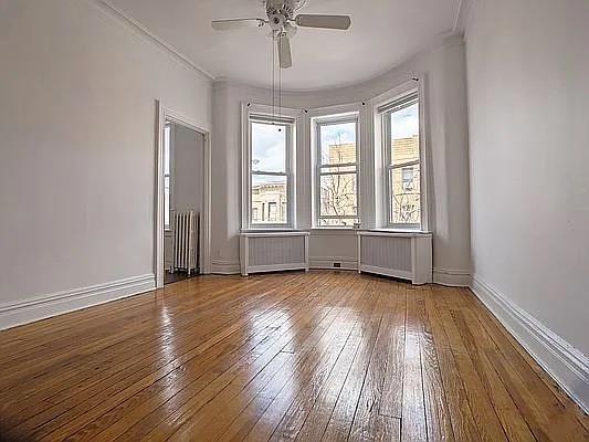 spare room with radiator heating unit and hardwood / wood-style floors