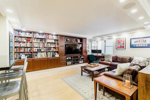 living room with ornamental molding and light hardwood / wood-style flooring