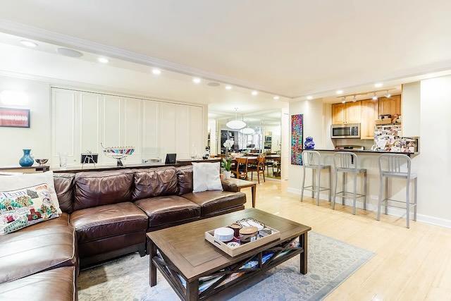 living room featuring ornamental molding and light hardwood / wood-style flooring