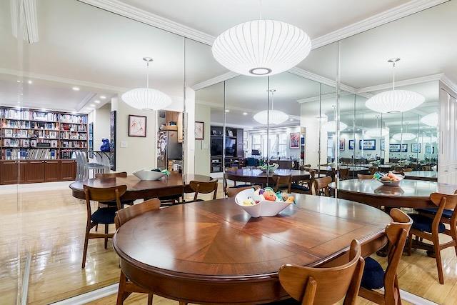 dining area with built in shelves, light hardwood / wood-style flooring, and ornamental molding